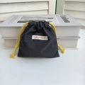 Detail of a black Oxford cloth drawstring pouch with a yellow cord and Mayrabbit label - Black Small