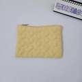 Macro shot of yellow quilted heart pouch featuring soft fabric and silver metal zipper - Yellow