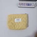 Vista detallada del neceser amarillo con acolchado de corazón, cremallera y etiqueta - Amarillo