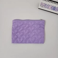 Macro view of purple quilted heart pattern on a small pouch with a smooth zipper detail - Purple