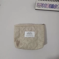 Detail shot of heart quilted beige cosmetic bag featuring a brand woven label on center - Khaki