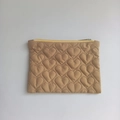 Detail of quilted heart pattern and bright yellow zipper on khaki small storage pouch - Brown