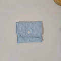 Detail of light blue quilted heart pouch with snap button and silky polyester texture - Blue