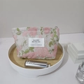 Détail de la trousse cosmétique en jacquard floral avec roses et étiquette de marque - Pivoine Gaufrée Rose