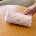 Vista ravvicinata dell'astuccio rosa trapuntato a cuore tenuto su un tavolo di legno - Rosa