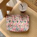 Blumen-Canvas-Tasche mit Tulpen und Logo-Detail auf einem geflochtenen Holzstuhl - Blumen Tulpe Rosa