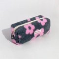 Dettaglio dell'astuccio in peluche grigio con fiori rosa ed etichetta del marchio - Fiore Rosa