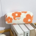 Dettaglio di un astuccio in peluche a fiori poggiato su libri con texture morbida - Fiore Arancione