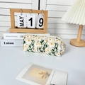 Detailed close-up of a daisy embroidered cosmetic bag on a cozy minimalist desk setup - Rectangular Pencil Case / Beige