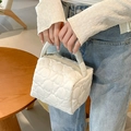 Detail of white quilted handbag with heart pattern and top metal zipper closure - White