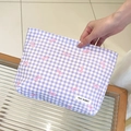 Dettaglio di una trousse a quadretti viola con motivi a fiocco rosa e logo del brand - Quadri Viola