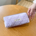 Macro shot of lavender quilted pencil case featuring embroidered bear head patterns - Purple
