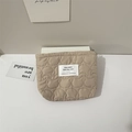 Detailed view of beige quilted makeup bag featuring cat head pattern and label - Quilted Cat Pattern Khaki