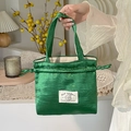 Bolso de satén verde con cordón y parche de conejo en un ambiente acogedor de casa - Verde