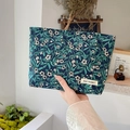 Detail of blue jacquard makeup bag with white floral pattern and brand logo tag - Navy Small Green Flower