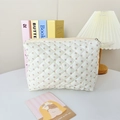 Detail of cream quilted makeup bag with floral print and soft fabric texture closeup - Medium White Flower Pattern / 23*16*6cm