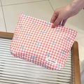 Detailopname van rood geruite make-uptas met blauwe strikken en geweven merklabel - Rood Geruit