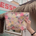 Detailed texture of floral fabric storage bag with brand label in an outdoor setting - Peony Pink