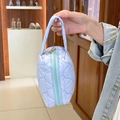 Handheld view of a quilted blue makeup bag featuring a soft texture and gold zipper detail - Blue