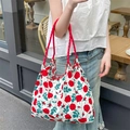 Florale Canvas-Tasche mit roten Rosen und Seilgriffen in einem Outdoor-Café-Ambiente - Romantische Rose