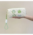 Detail of white quilted heart patterns with apple and bow embroidery on makeup bag - Green Apple Pencil Case