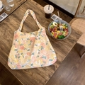 Flat lay of vintage floral canvas tote bag on a wooden table near a fresh salad and coffee - Peony Yellow