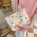 Detail of floral makeup bag featuring colorful rose patterns and a brand logo tag - Peony Yellow