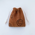 Dettaglio del sacchetto in velluto a coste marrone con coulisse e motivo a faccina sorridente - Marrone Sorriso