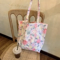 Détail d'un sac cabas en toile fleurie avec écusson lapin LOVE dans un café cosy - Pivoine Rose