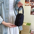 Détail du tissu noir matelassé à motifs de cœur sur une trousse de maquillage rembourrée - Noir