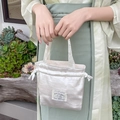 Dettaglio borsa a secchiello in velluto bianco con etichetta di coniglio e manico - Crema