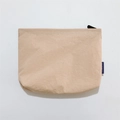 Close-up of beige waterproof nylon cosmetic bag with wrinkled texture and blue brand label - Khaki
