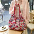 Dettaglio di borsa tote in tela a fiori con manico in corda rossa ed etichetta logo - Fiori Colorati