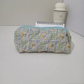 Detailed view of the quilted floral fabric and blue zipper of the stationery pouch - Green Plaid Floral