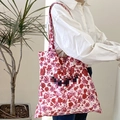 Borsa tote in tela a fiori rossi con scritta PARIS indossata da una modella - Stile Rosa Rossa