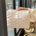 Close-up of quilted heart pattern and brand label on a cream cosmetic storage bag - Khaki