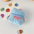 Primer plano del mini estuche acolchado azul claro con adorno de perla en la cremallera - Flor Acolchada Azul