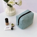 Dettaglio della trousse in velluto a coste verde menta con cerniera su tavolo bianco - Grigio Blu Chiaro