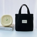Detalle del bolso tote de pana negra con etiqueta de marca y elementos decorativos - Negro