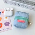 Détail pochette bleue matelassée à motifs cœurs avec fermeture verte et breloque perle - Bleu