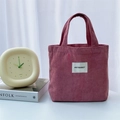 Dettaglio della borsa tote in velluto a coste rosa antico con etichetta tessuta - Rosa loto