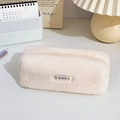 Dettaglio dell'astuccio in peluche beige con cerniera e logo mayrabbit su tavolo - Velluto Teddy Bianco