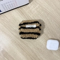 Detailopname van pluchen oortelefoonhoes met bruine strepen en AirPods-model - Lange Koord Pluche Bruin & Zwart Strepen