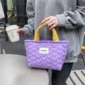 Detail of purple quilted heart tote bag with yellow handles and brand logo tag - Purple Heart Yellow Strap