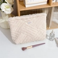Close-up of cream white plush cosmetic bag featuring woven texture and rainbow logo tag - Chinese Knot Milky White