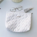 Dettaglio ravvicinato della borsa da toilette bianca trapuntata con cuori e cerniera - Bianco