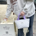 Dettaglio del motivo a cuore trapuntato e manici lavanda su una borsa bianca - Cuore bianco tracolla viola