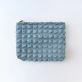 Detail of light blue bubble textured makeup bag with premium metal zipper closure - Blue