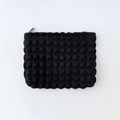 Detailed view of the black popcorn texture and zipper on this cloud cosmetic pouch - Black