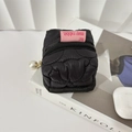 Quilted black mini pouch with pearl zipper detail shown on a magazine next to earbuds - Black